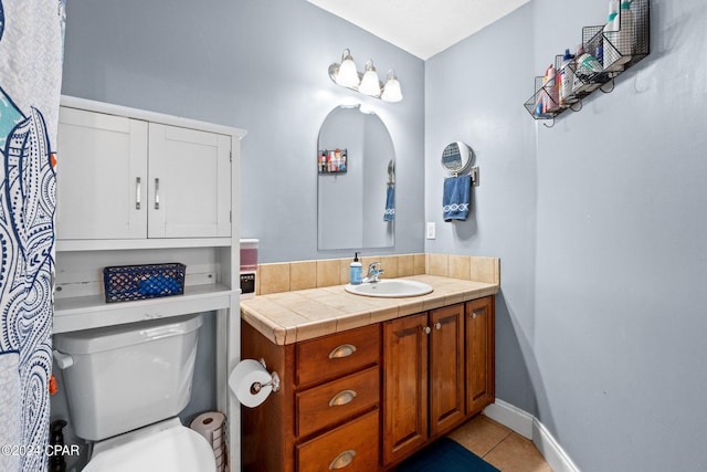 bathroom with toilet, vanity, and tile patterned flooring