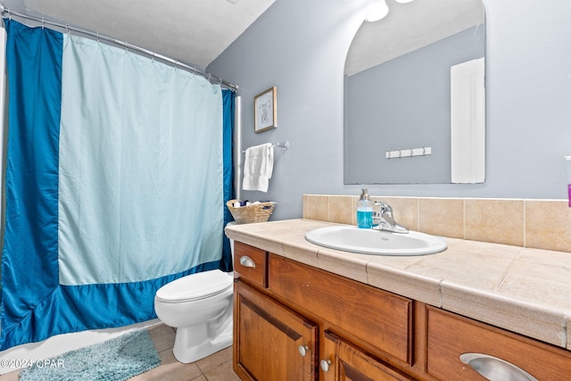 bathroom with toilet, vanity, and tile patterned floors