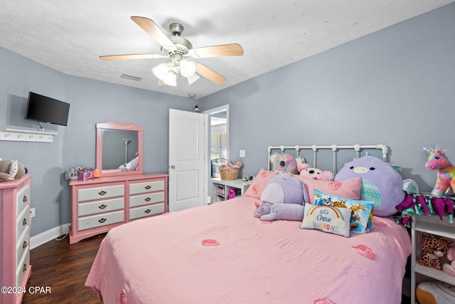 bedroom with dark hardwood / wood-style flooring, a textured ceiling, and ceiling fan