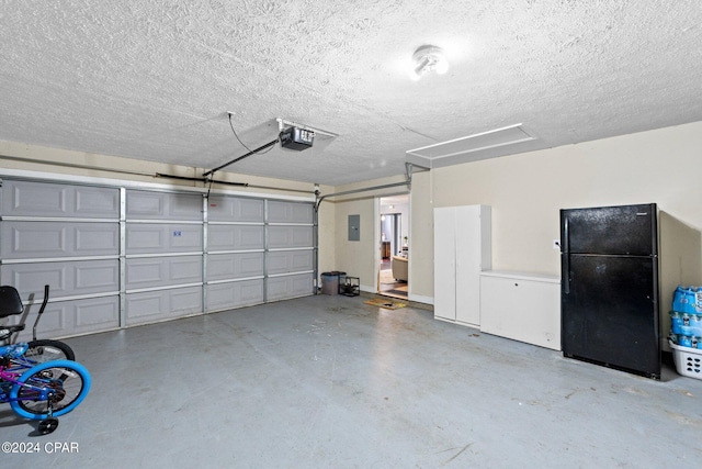 garage featuring black refrigerator, a garage door opener, and electric panel