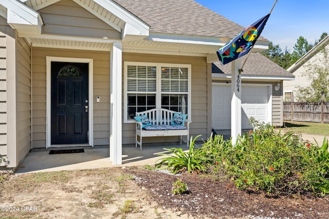 entrance to property with a garage and covered porch