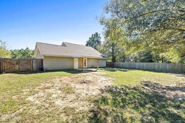 rear view of house featuring a lawn