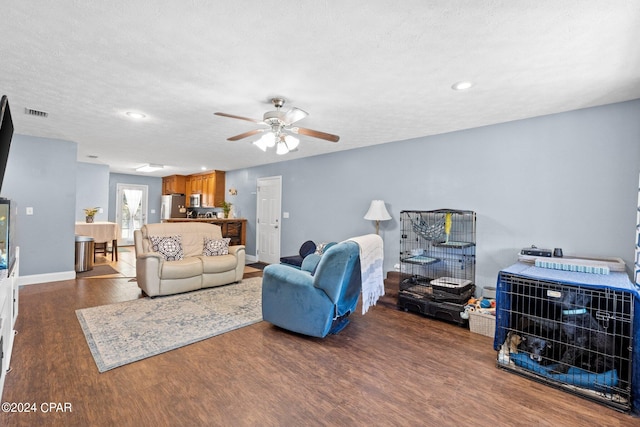 living room with hardwood / wood-style floors, a textured ceiling, and ceiling fan