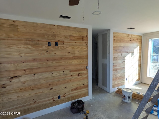 interior space featuring wood walls and concrete flooring