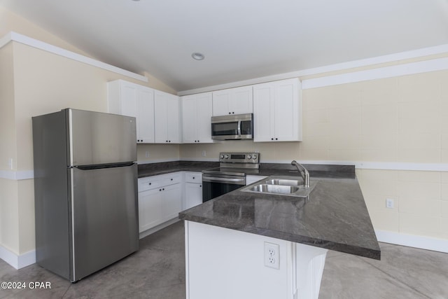 kitchen featuring white cabinets, sink, a breakfast bar area, vaulted ceiling, and stainless steel appliances