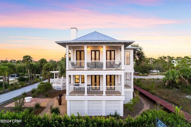 back house at dusk with a balcony