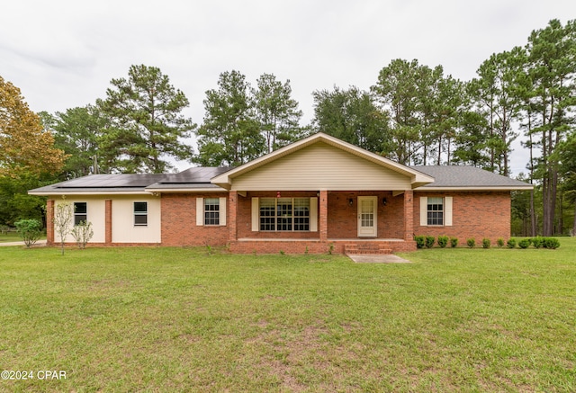 single story home with a front yard and solar panels