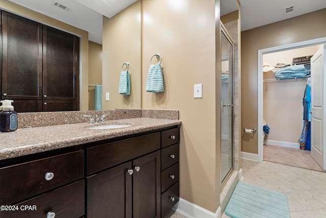 bathroom featuring vanity, tile patterned floors, and an enclosed shower