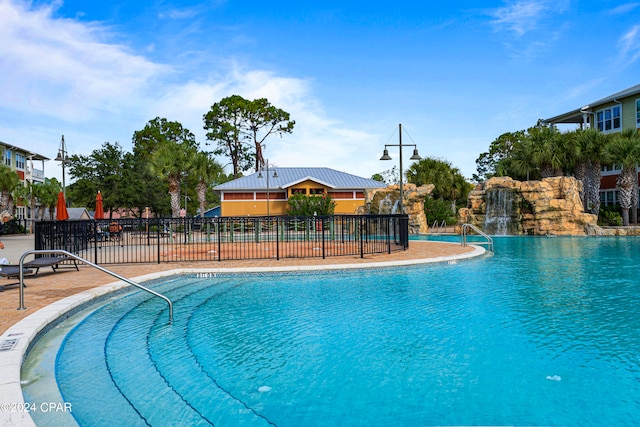 view of swimming pool with pool water feature