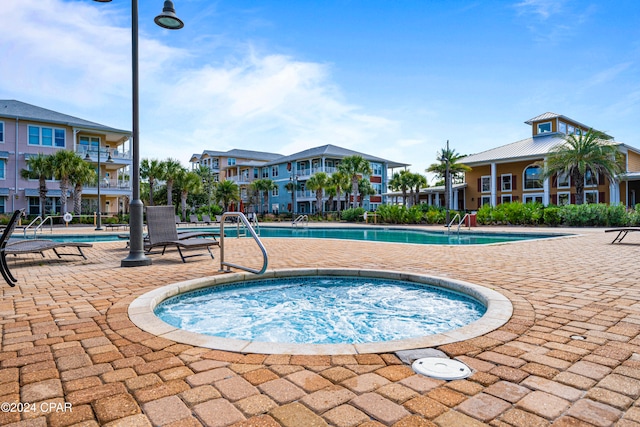 view of swimming pool featuring a hot tub