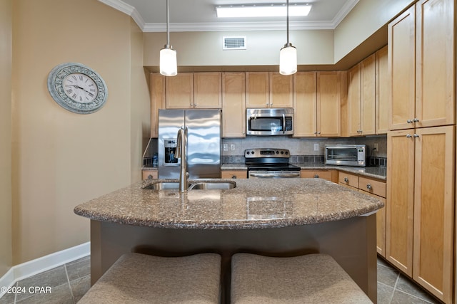 kitchen featuring decorative light fixtures, a kitchen island with sink, and appliances with stainless steel finishes