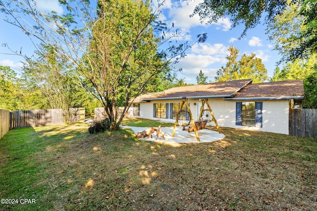 back of property with a yard and a patio