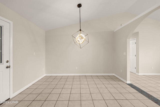 tiled spare room with an inviting chandelier and lofted ceiling