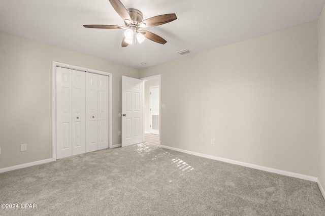 unfurnished bedroom featuring ceiling fan, a closet, and carpet flooring