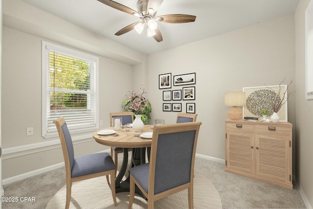 carpeted dining area with ceiling fan