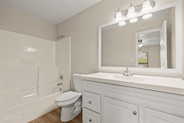 full bathroom featuring ceiling fan, vanity, hardwood / wood-style floors, toilet, and shower / tub combination