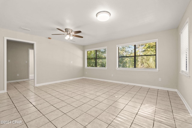 tiled spare room featuring ceiling fan