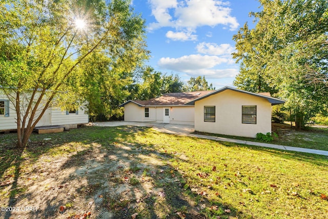 back of house featuring a lawn and a patio area