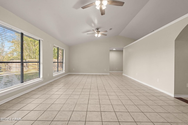 spare room featuring ceiling fan, light tile patterned floors, and vaulted ceiling