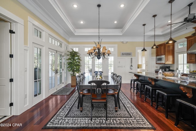 dining room with french doors, ceiling fan with notable chandelier, a raised ceiling, crown molding, and dark hardwood / wood-style floors