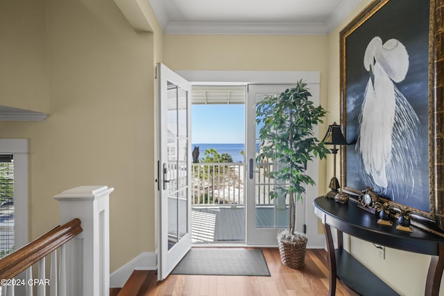 interior space featuring crown molding, french doors, a water view, and hardwood / wood-style flooring