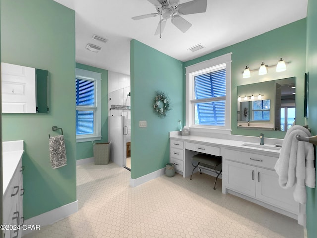 bathroom featuring ceiling fan, a shower with shower door, and vanity