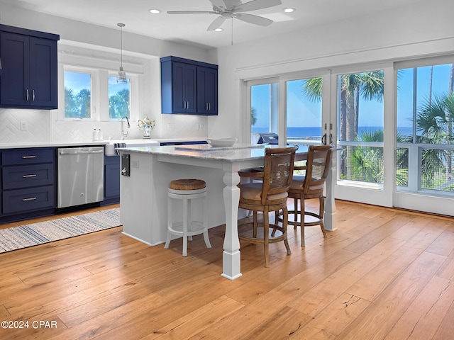 kitchen with dishwasher, light hardwood / wood-style flooring, blue cabinets, and plenty of natural light