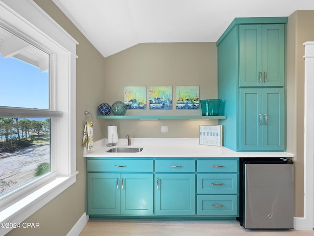 interior space featuring light hardwood / wood-style flooring, stainless steel fridge, sink, and vaulted ceiling