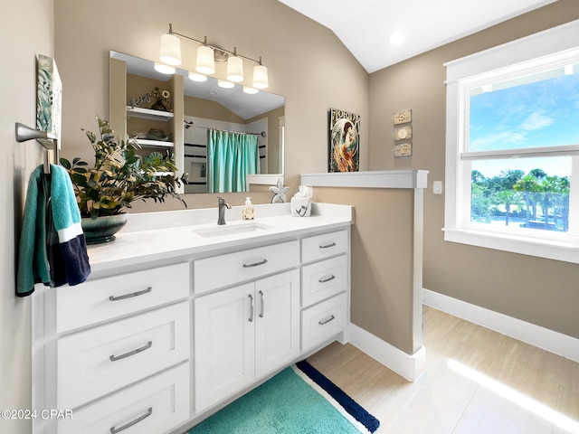 bathroom featuring vanity, wood-type flooring, and vaulted ceiling