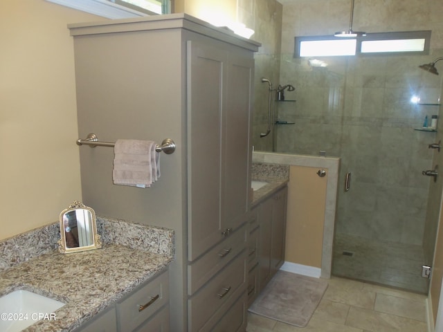 bathroom featuring tile patterned flooring, a shower with door, and vanity