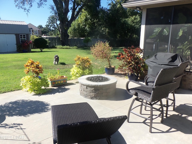 view of patio featuring area for grilling, a storage shed, and a fire pit