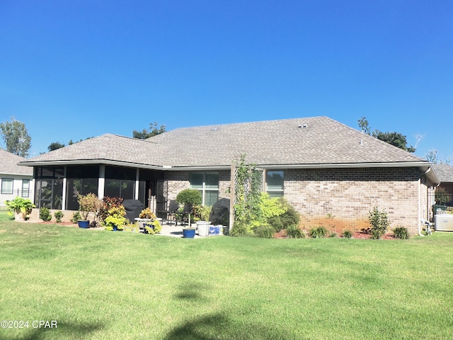 back of house with a sunroom, a yard, and a patio area