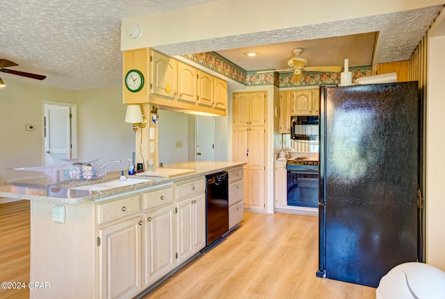 kitchen with black appliances, sink, light hardwood / wood-style flooring, ceiling fan, and a textured ceiling