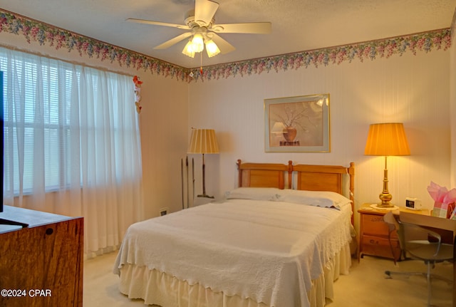 bedroom featuring ceiling fan, light carpet, and multiple windows