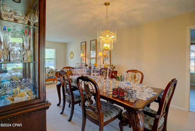 dining space featuring light carpet, a textured ceiling, and an inviting chandelier