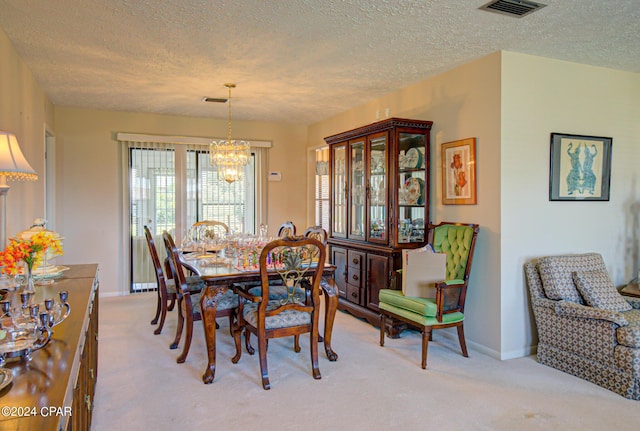 dining space with a textured ceiling, light colored carpet, and an inviting chandelier