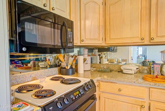 kitchen featuring light brown cabinets, electric range, and light stone counters