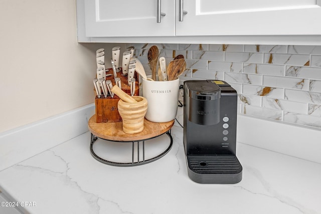 room details featuring decorative backsplash and white cabinetry