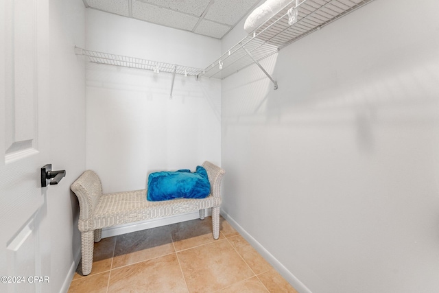 spacious closet with tile patterned flooring and a drop ceiling