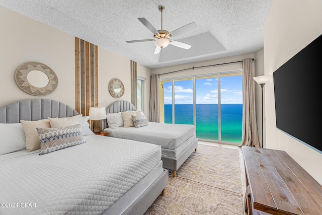 bedroom with a textured ceiling, access to outside, and ceiling fan