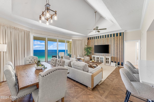 living room featuring ceiling fan with notable chandelier, a textured ceiling, a raised ceiling, crown molding, and light parquet flooring