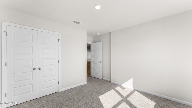 unfurnished bedroom with carpet flooring and a closet