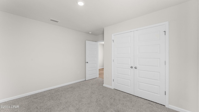 unfurnished bedroom with carpet floors and a closet