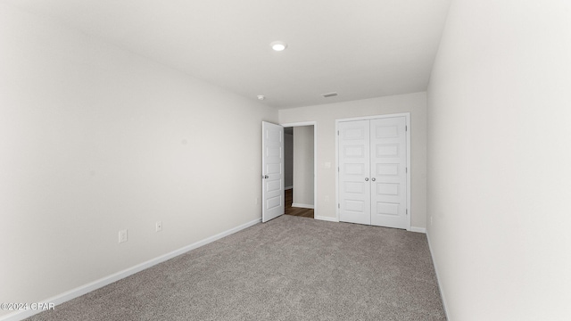 unfurnished bedroom featuring carpet flooring and a closet