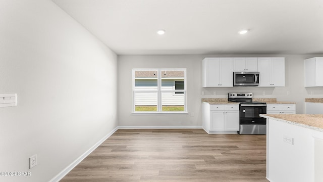 kitchen featuring white cabinetry, appliances with stainless steel finishes, and light hardwood / wood-style flooring