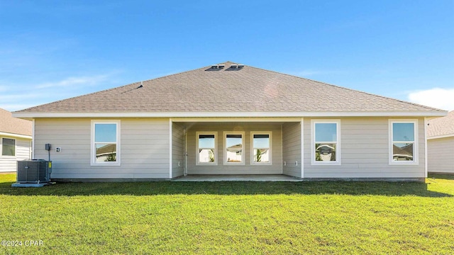 rear view of property with a lawn and central air condition unit