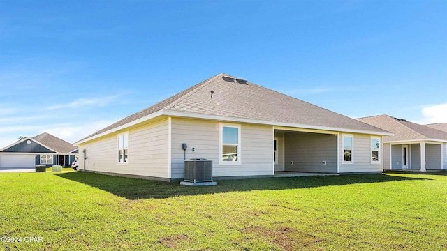 back of property featuring a lawn and cooling unit