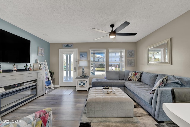 living room featuring a textured ceiling, wood-type flooring, and plenty of natural light