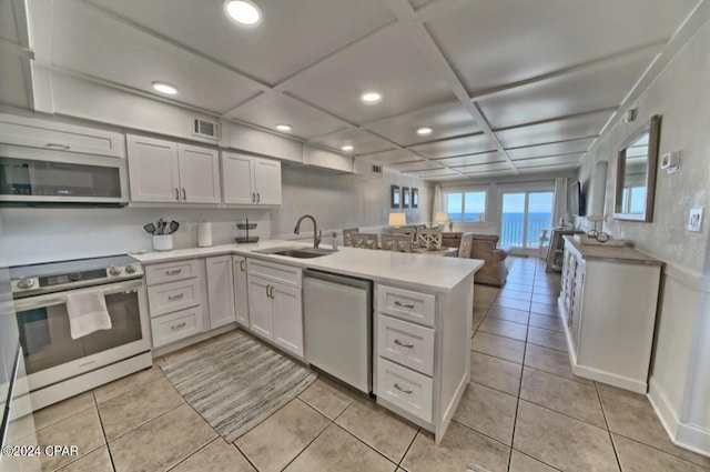 kitchen with white cabinets, kitchen peninsula, sink, and appliances with stainless steel finishes