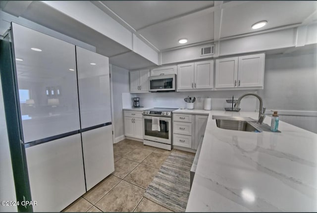 kitchen with white cabinets, light stone countertops, sink, and appliances with stainless steel finishes